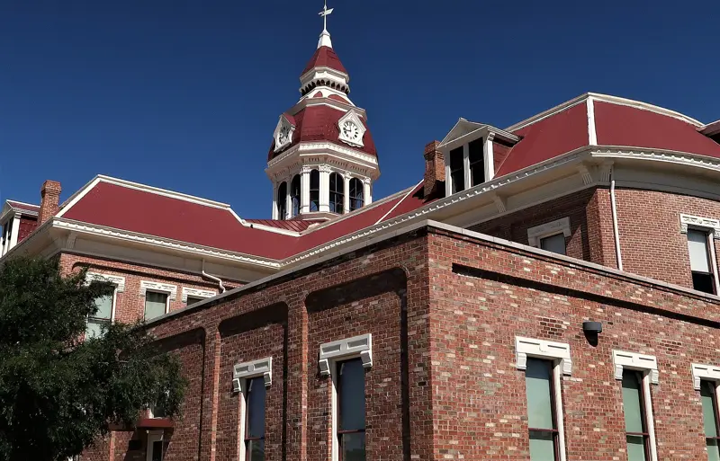 Red-roofed clock tower atop a historic brick building in Florence, Arizona
